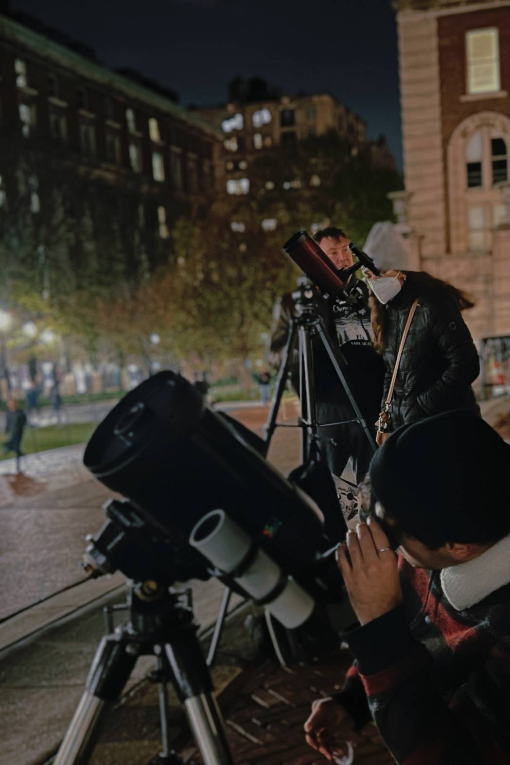 People looking through telescopes on Columbia's College Walk